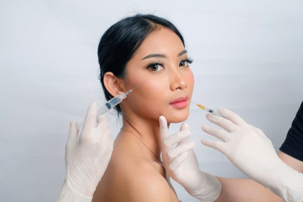 Close-up of a professional administering a dermal filler dissolving treatment to safely remove unwanted filler and restore natural facial contours.